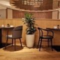 Wysoka kremowa donica ceramiczna szkliwiona w kształcie urny w restauracji